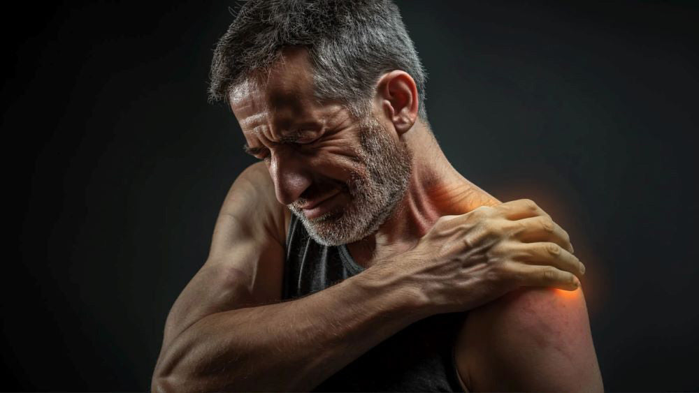 Uomo con dolore alla spalla, area dolorante evidenziata in rosso.