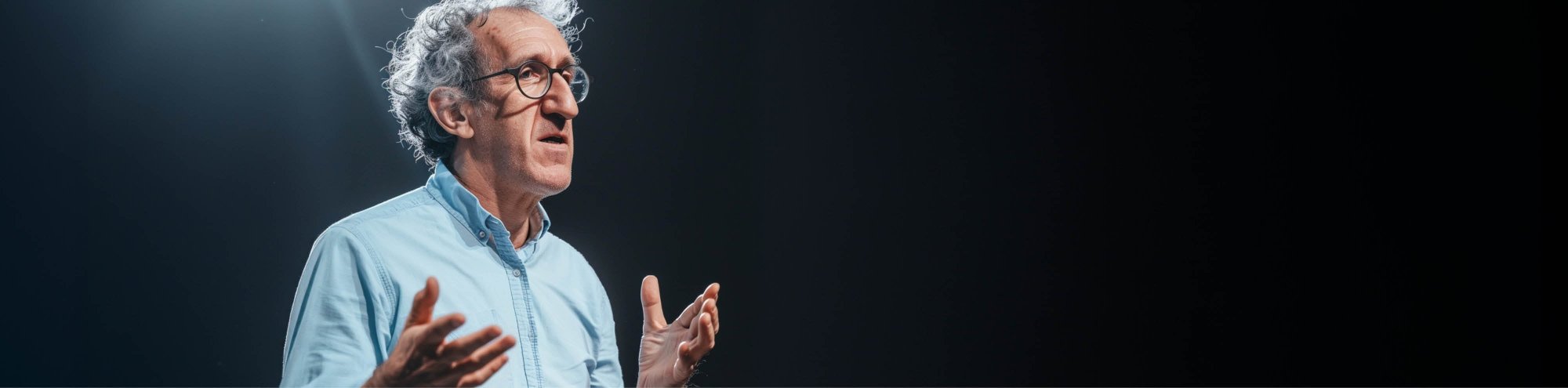 Dottore in camicia mentre spiega con le braccia aperte.